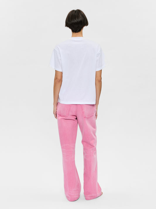 Person wearing a white t-shirt and pink pants on a light gray background