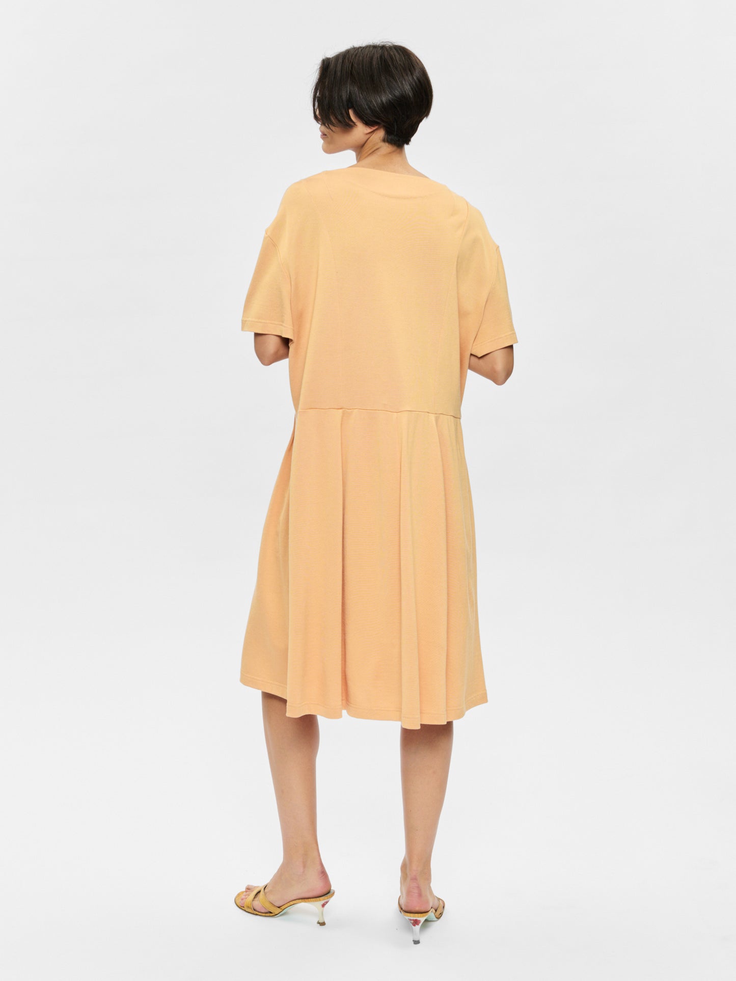 Woman wearing a yellow dress on a white background