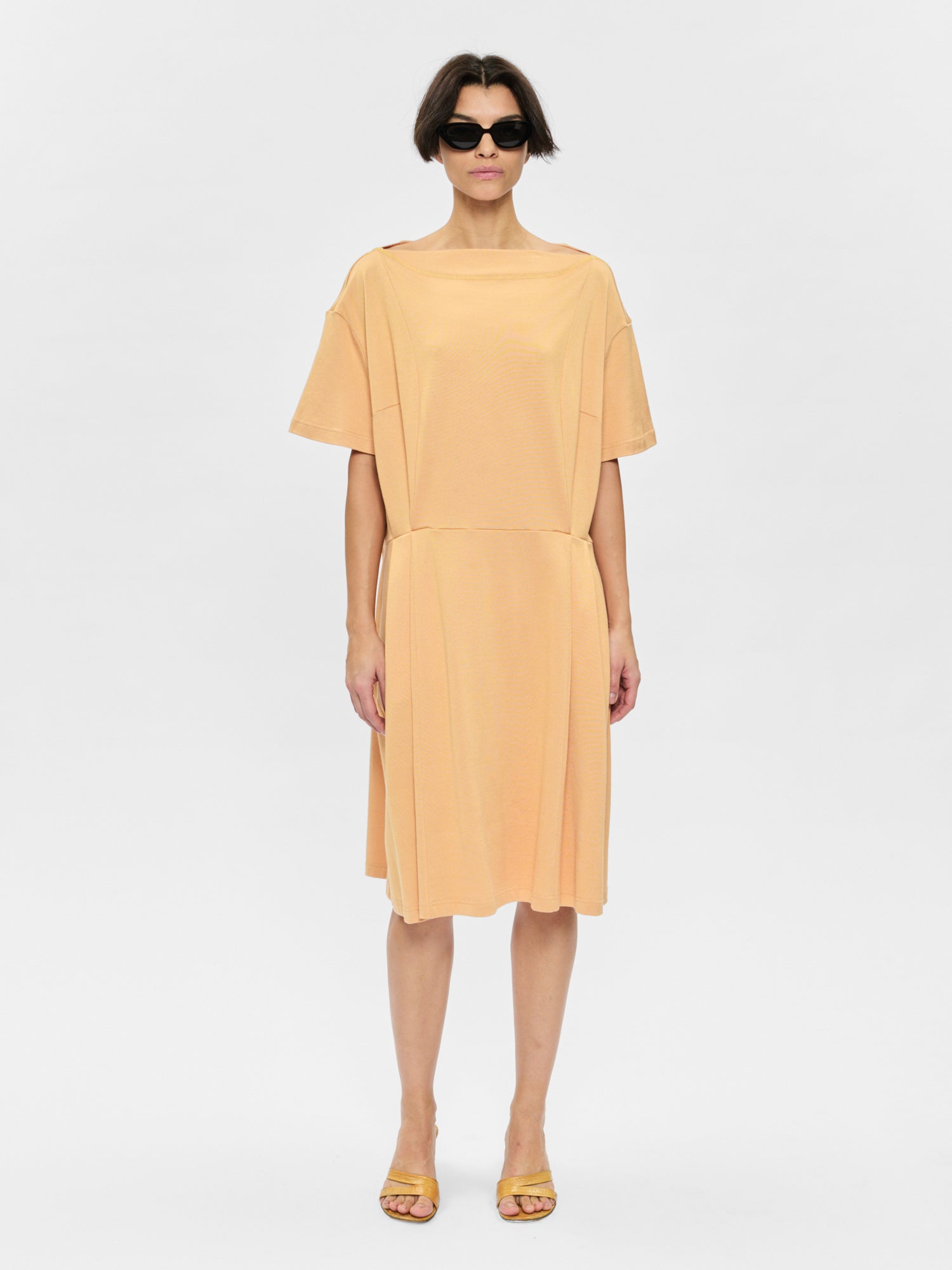 Woman wearing a yellow dress on a white background