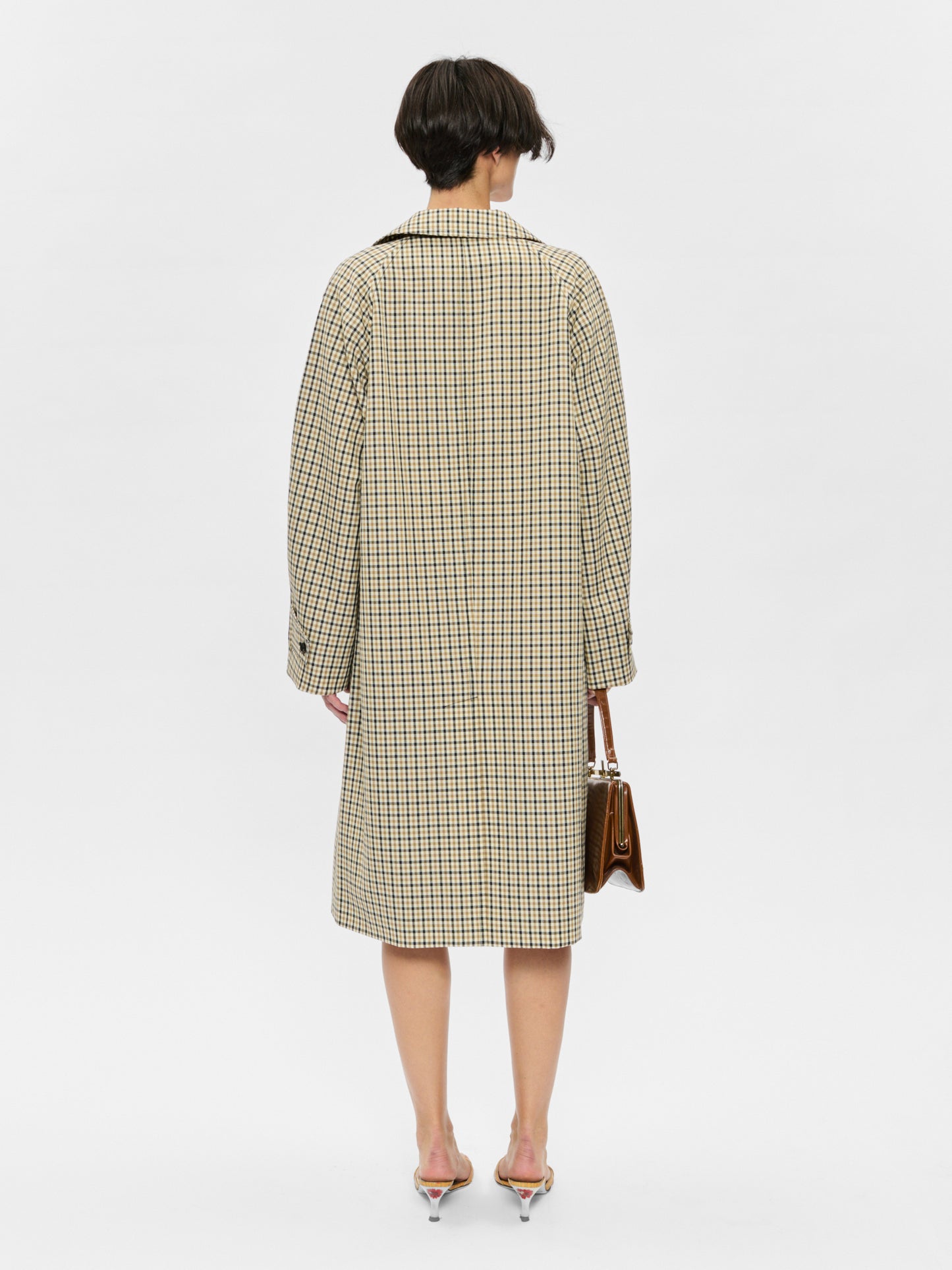 Person wearing a checkered coat on a white background