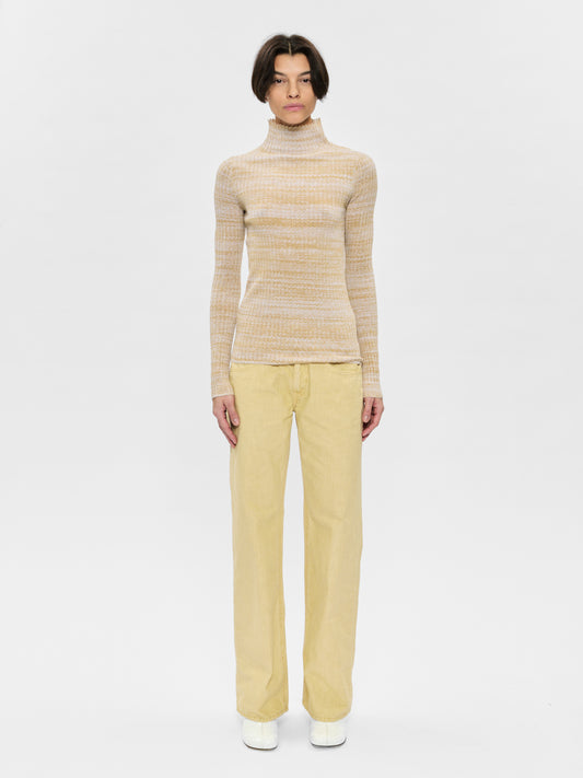 Person wearing a striped sweater and yellow pants on a white background