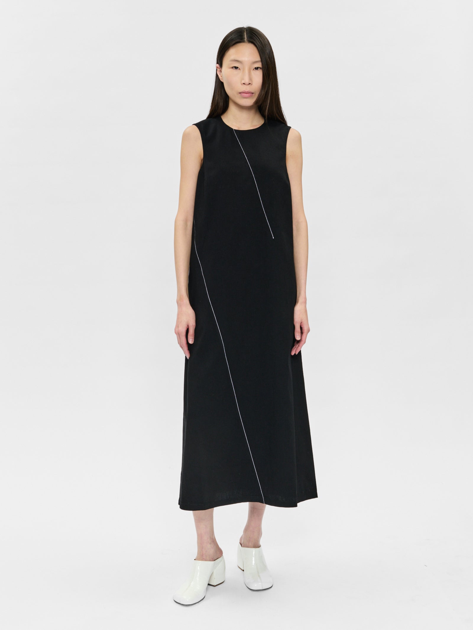 Woman wearing a black sleeveless dress on a white background