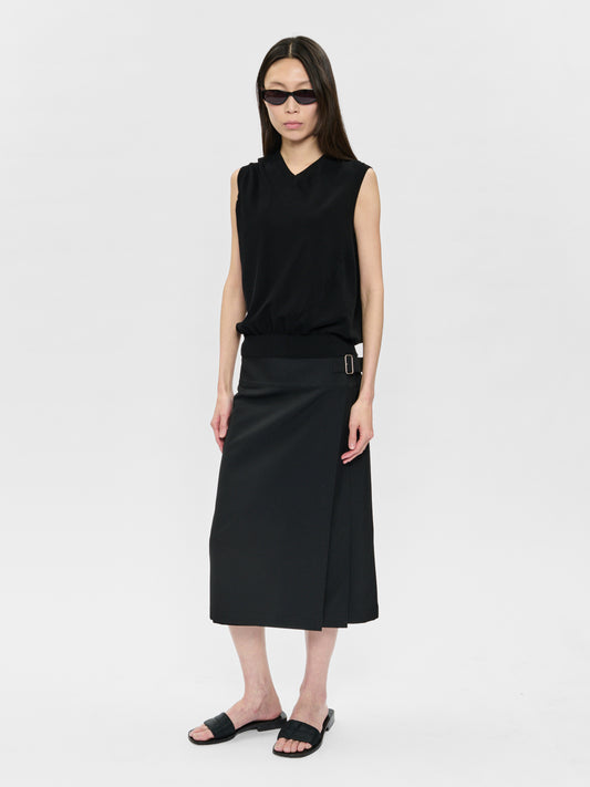 Woman wearing a black sleeveless top and skirt on a white background