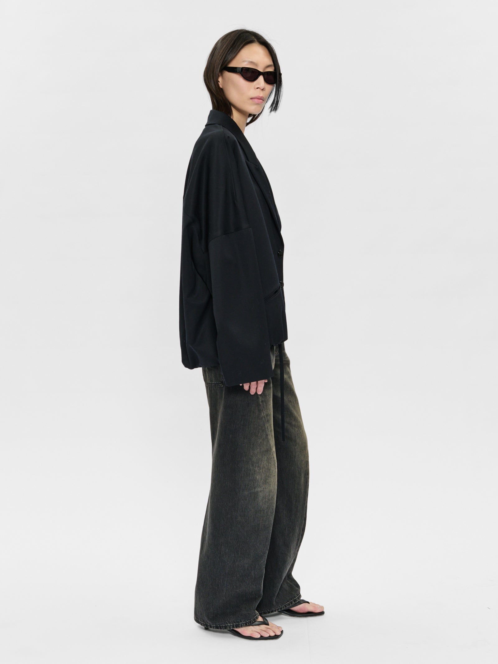 Person wearing a black outfit with wide-leg pants on a white background