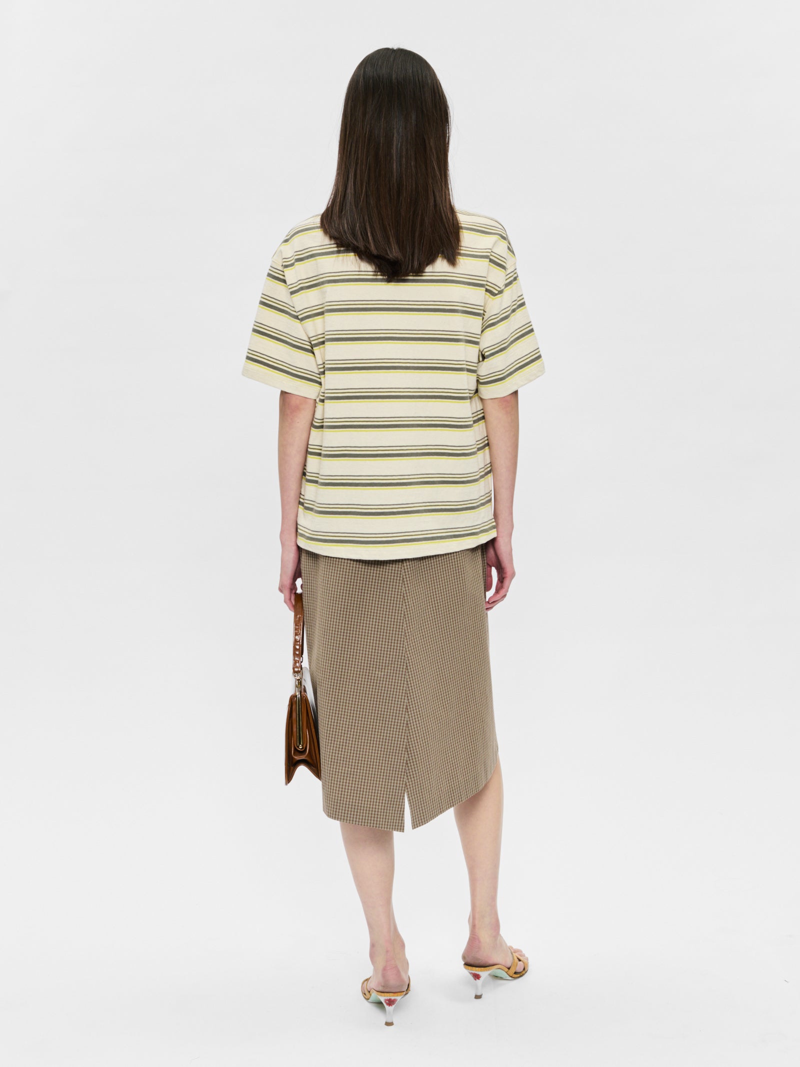 Woman wearing a striped shirt and skirt on a white background